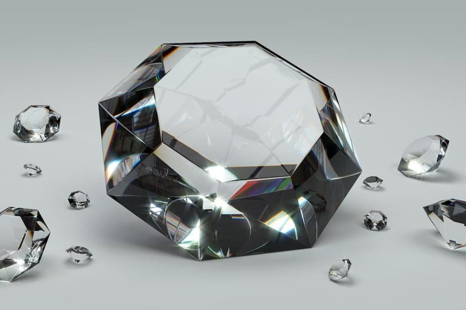 A multi-faceted cut diamond reflecting soft light against a neutral gray background.