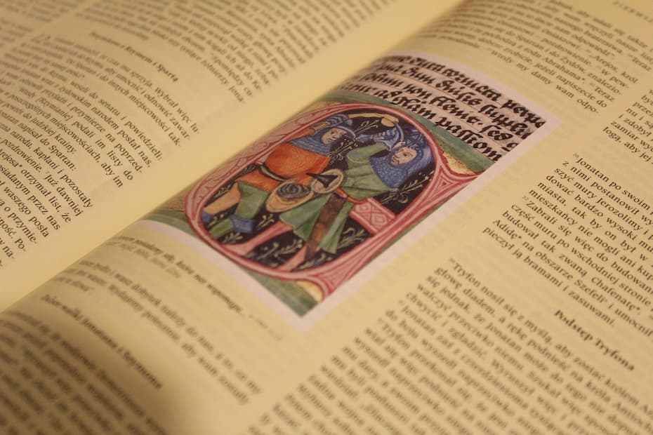 A close-up side-angle view of an open book focusing on a few lines of crisp text while the surrounding pages blur.