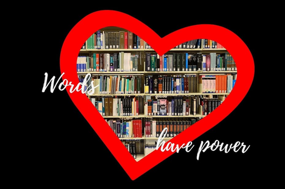 Open book with pages folded into a heart shape in front of a bookshelf.